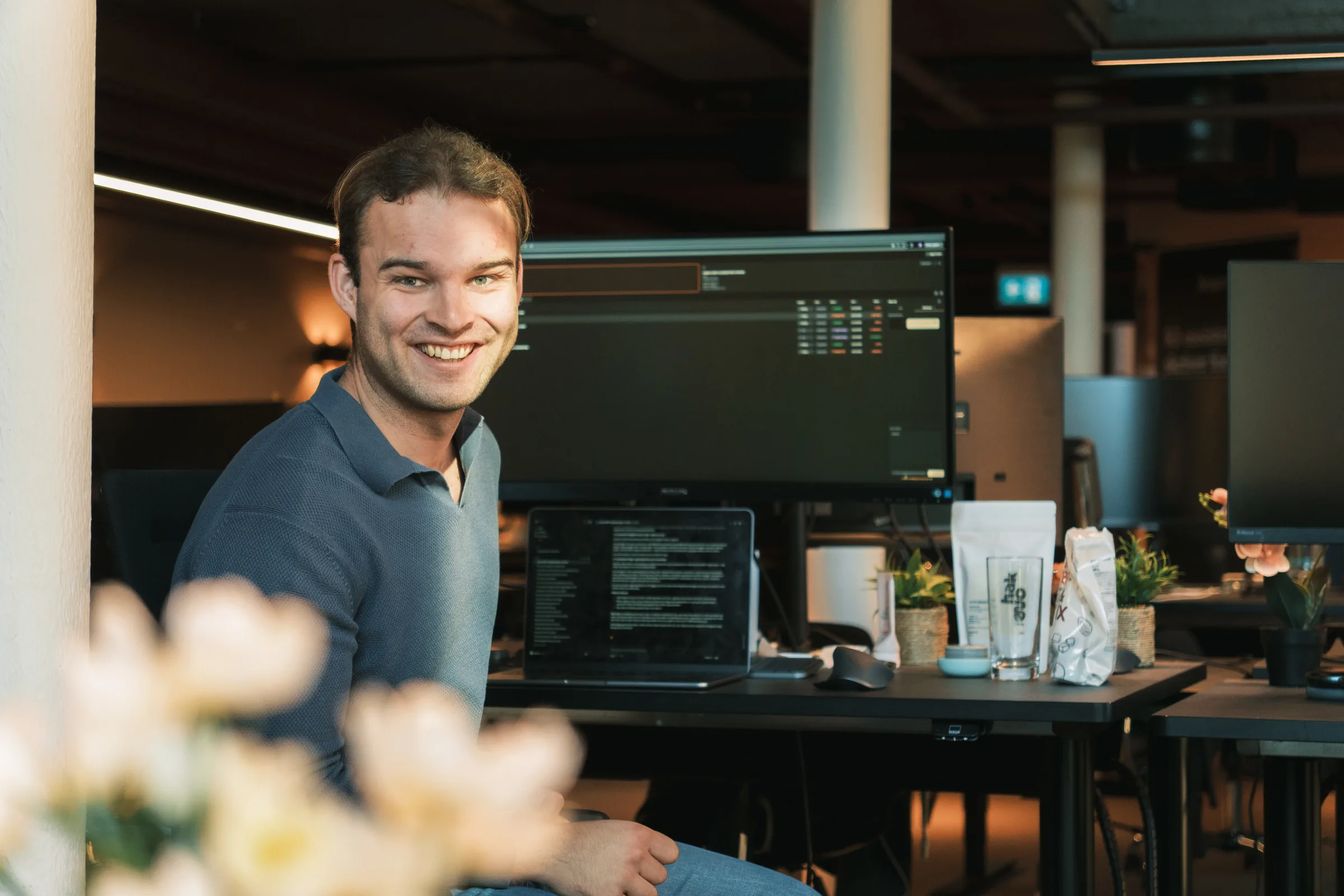 Smilende regnskapsfører ved skjermene på kontoret